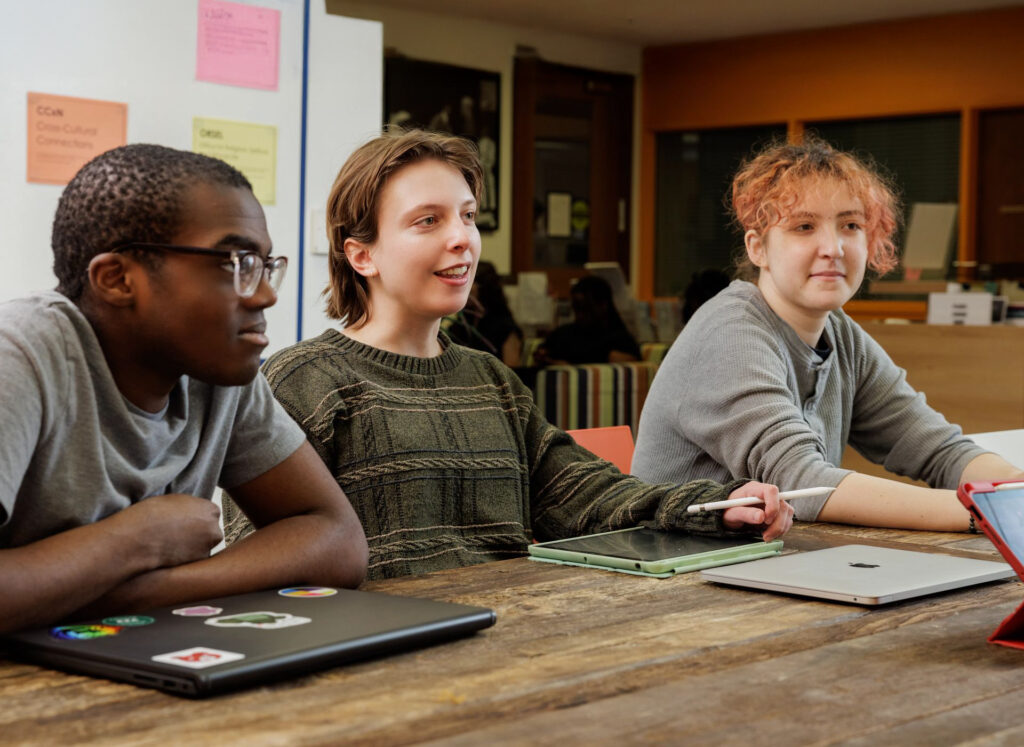 Students gather around a table